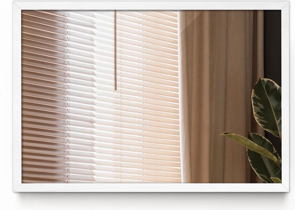 A close-up view of a window with blinds and a curtain, with a plant in the foreground.