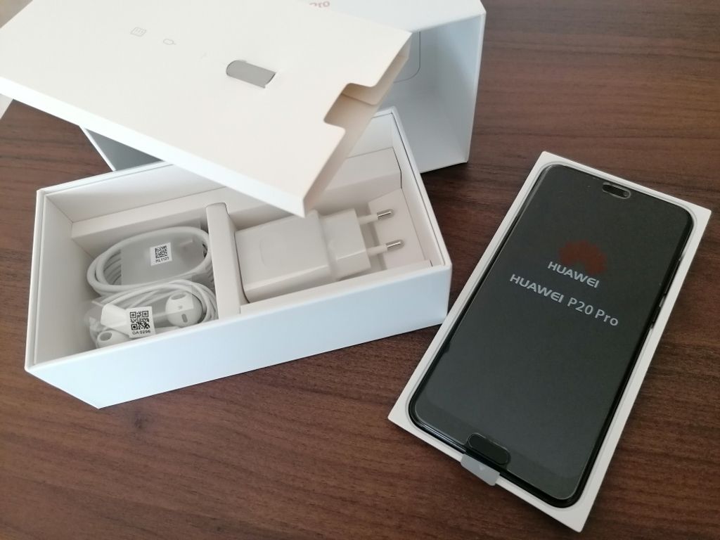 The image shows the contents of a Huawei P20 Pro smartphone box, including the phone itself and its accessories.