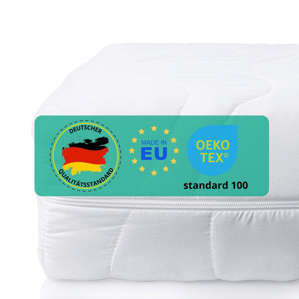 A close-up of a white mattress with a teal label showing certifications and origin information.