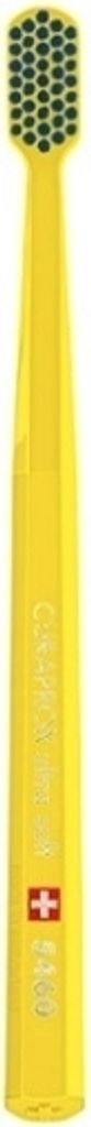 A yellow toothbrush with a patterned head and a small red and pink cross symbol on the body.