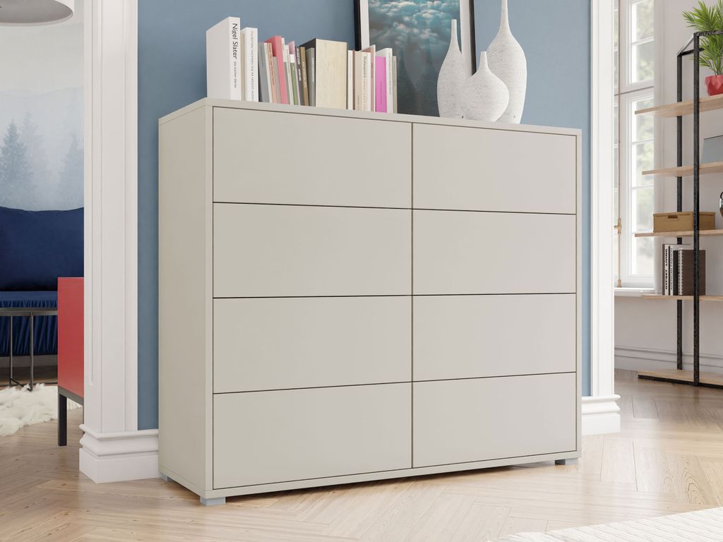 A modern dresser with books and vases on top, placed in a well-lit room with blue walls and a window.