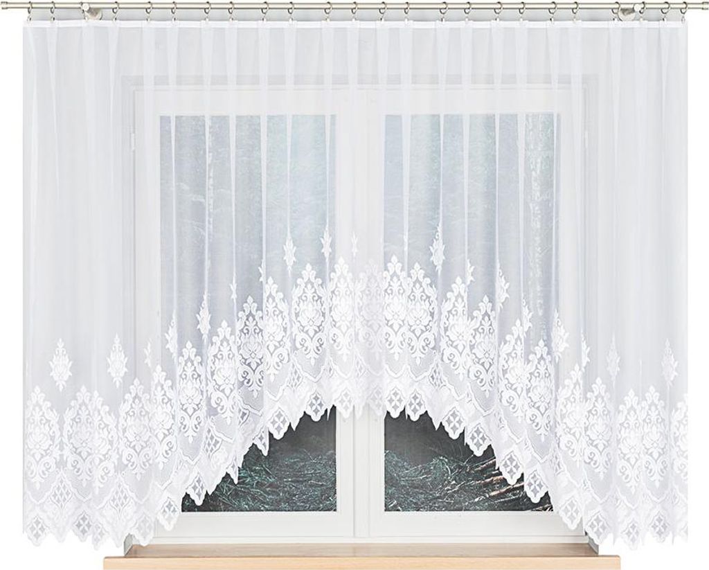 A white lace curtain with a decorative pattern is hung over a window.