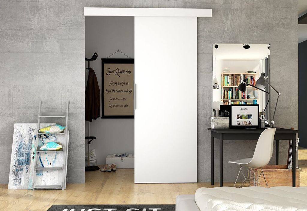 A modern interior scene featuring a white sliding door, a desk with a laptop, and decorative items.