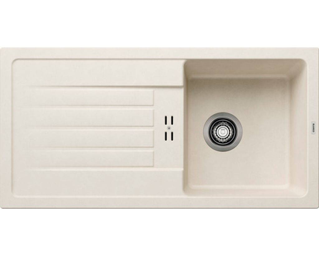 A top-down view of a cream-colored kitchen sink with a drainboard and a stainless steel drain.