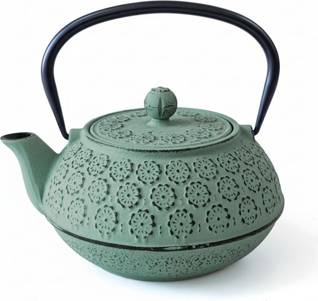 A green cast iron teapot with a black handle is shown against a white background.