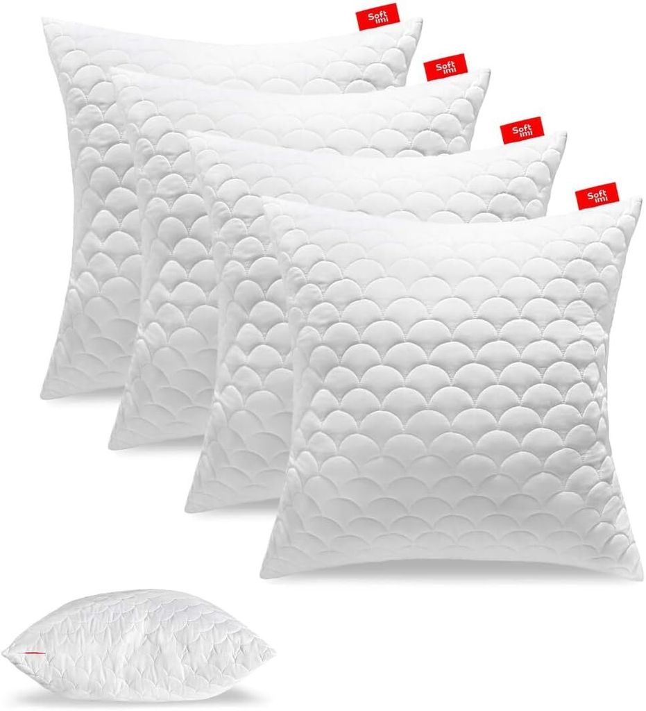 A set of white pillows arranged in a staggered formation, with one pillow placed separately in the foreground.