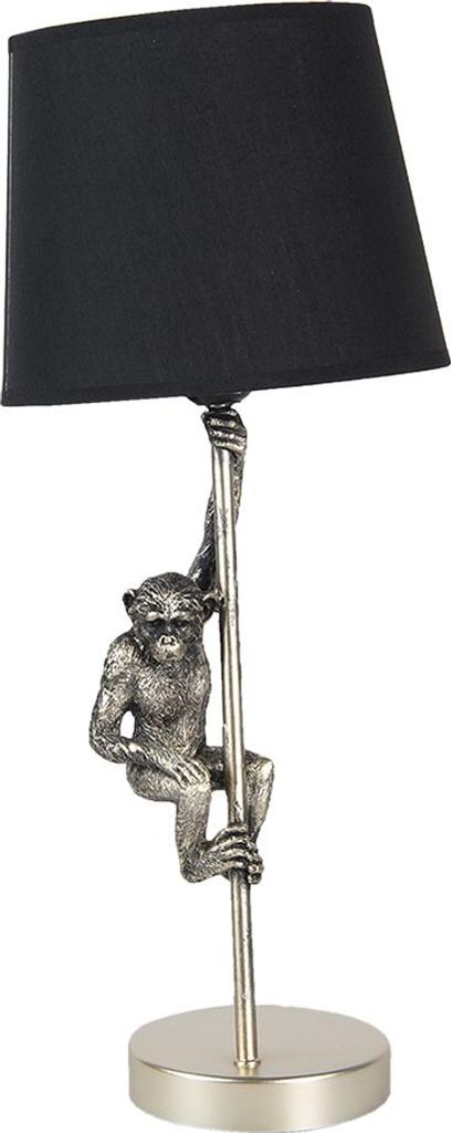 A table lamp with a monkey figure climbing a pole.
