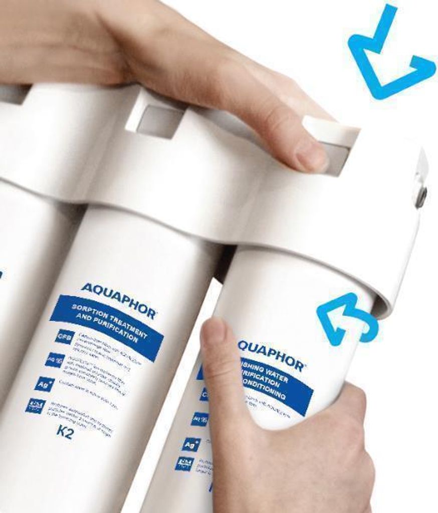 Hands are shown replacing a water filter cartridge in a water filtration system.