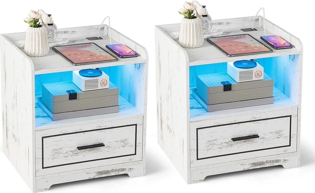 Two white distressed wood-effect nightstands with LED lighting, tablets, phones, and decorative items.