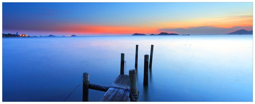 Wallario Wandbild aus Acryl, 200 x 80 cm, freischwebende Optik - Steg im Wasser - Abendstimmung am Meer