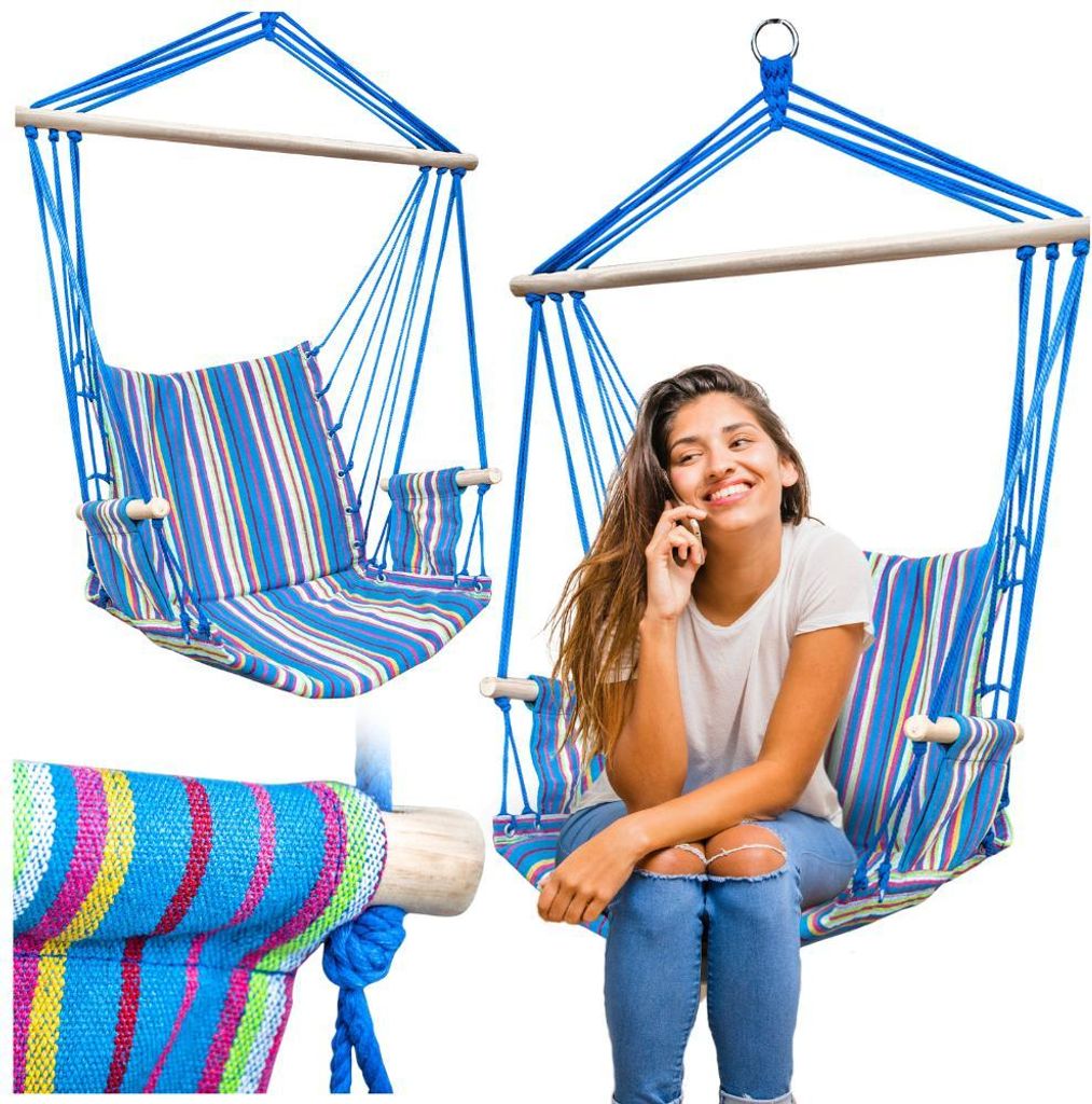 A woman is sitting in a striped hammock chair and talking on her phone.