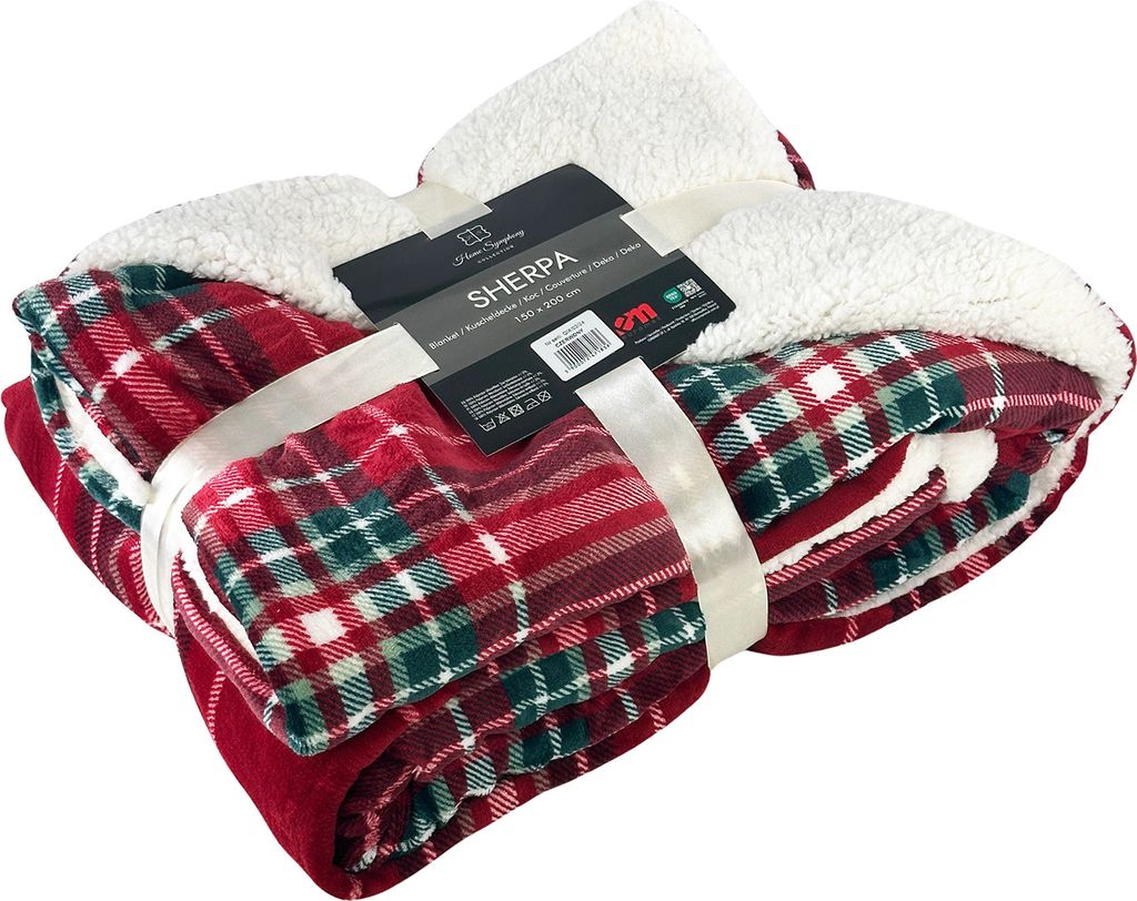 A folded plaid Sherpa blanket tied with a ribbon, with a product tag attached.