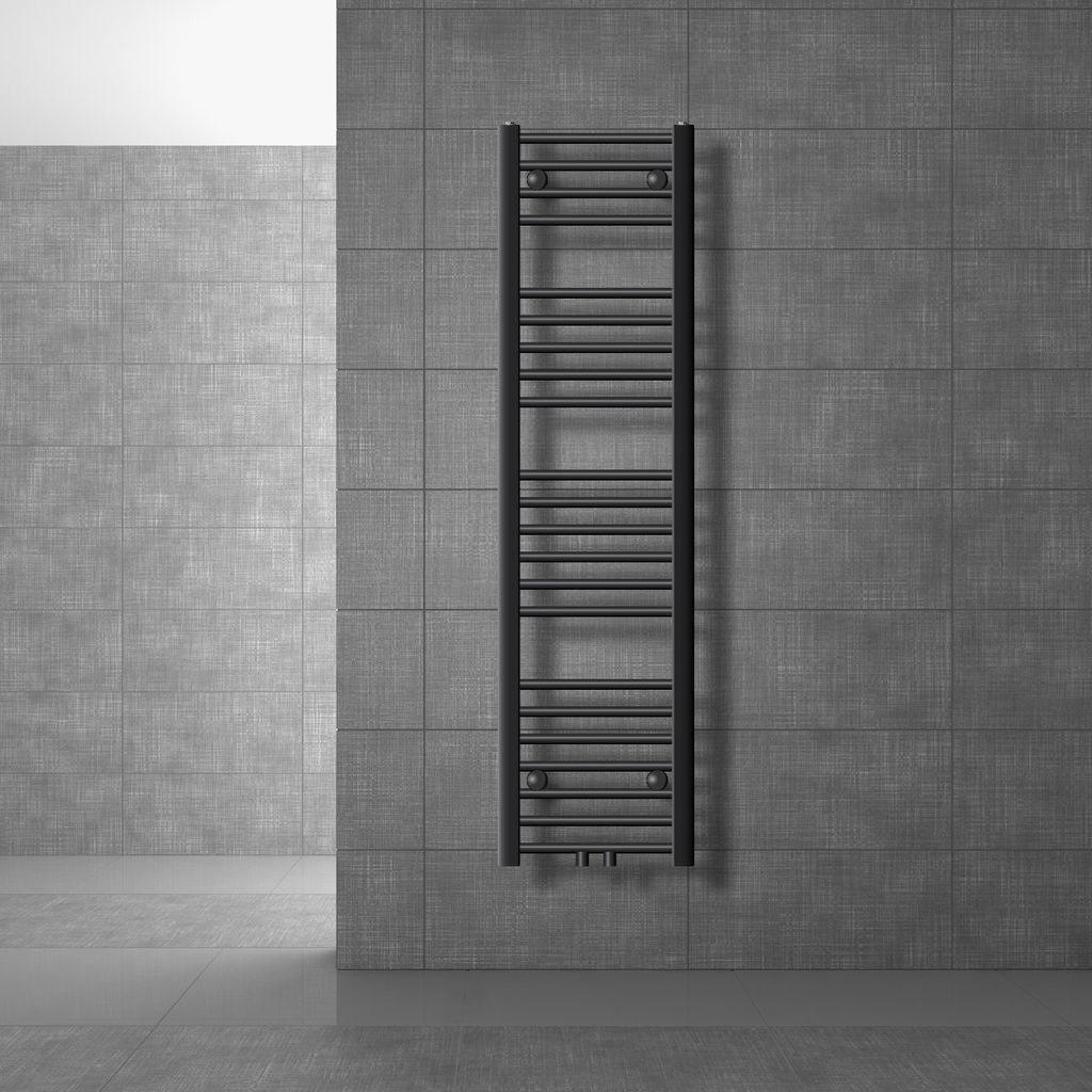 A black radiator mounted on a gray tiled wall in a bathroom.