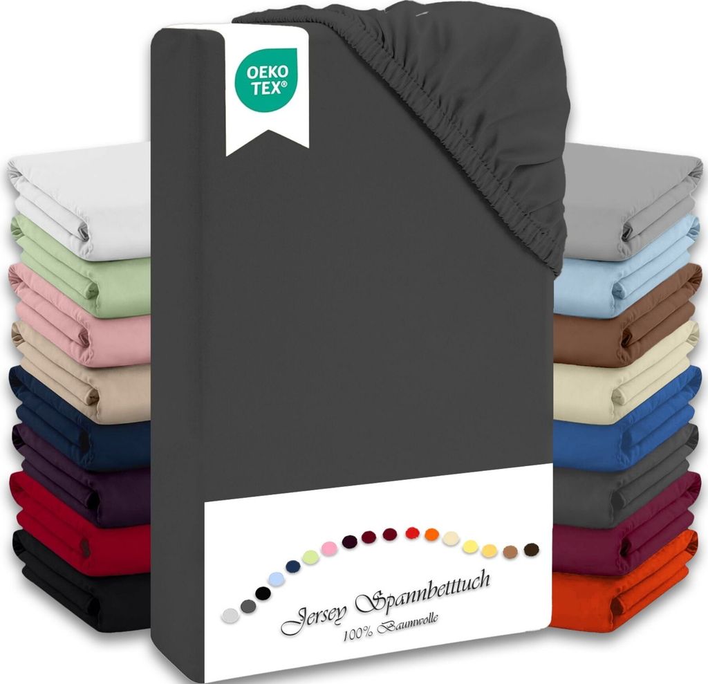 A stack of folded fitted sheets in various colors, with a dark gray fitted sheet prominently displayed in the foreground.