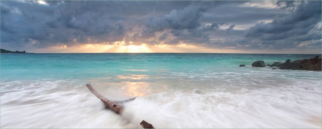 Wallario Poster - Wellen am Strand bei Sonnenuntergang, Kunstdruck Größe: 80 x 200 cm
