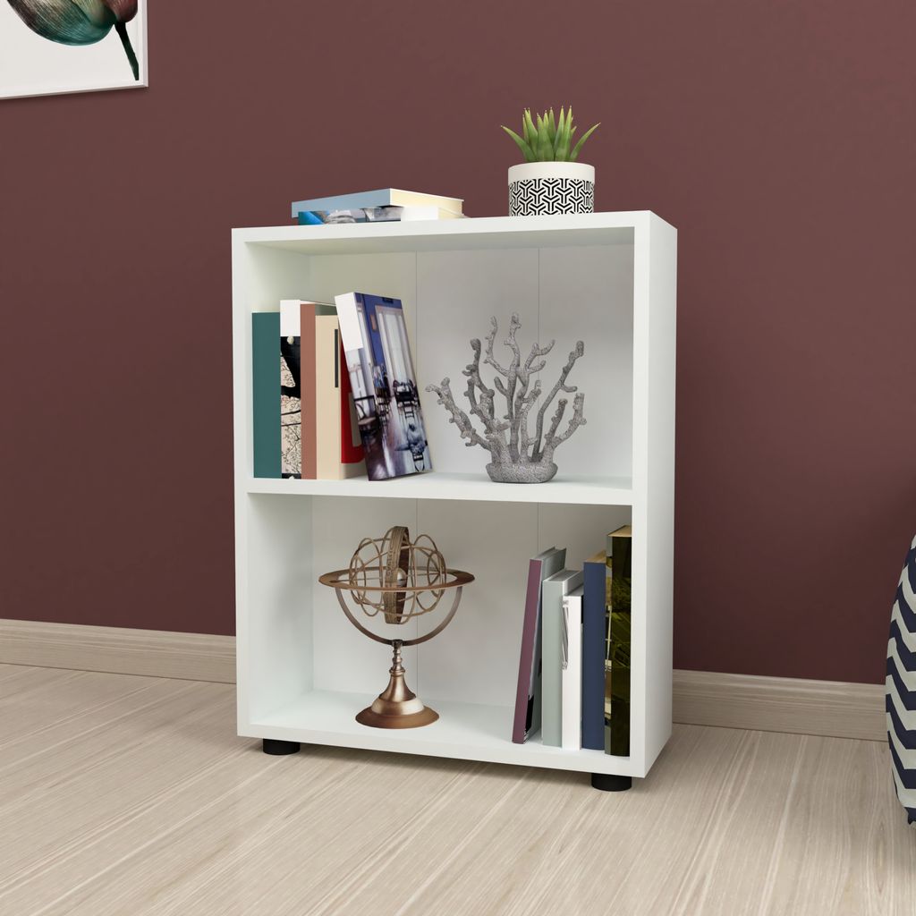 A white bookshelf with two shelves, filled with books and decorative items, placed on a light-colored wooden floor against a dark red wall.