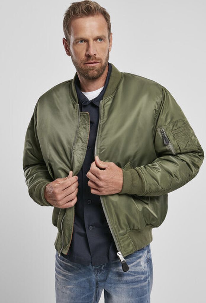 A man wearing a green bomber jacket over a navy blue shirt.