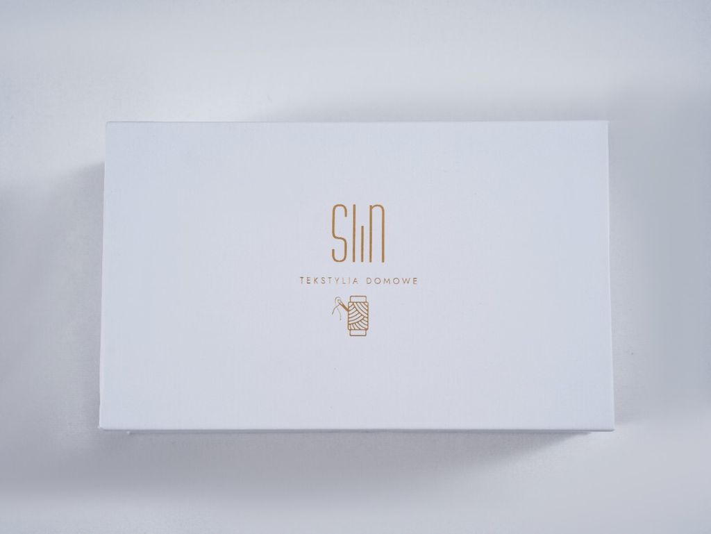 A white box with a gold logo and text.
