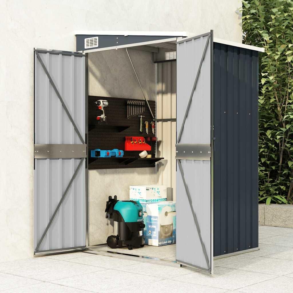 An open garden shed with tools and storage inside, placed outdoors on a paved patio next to greenery.