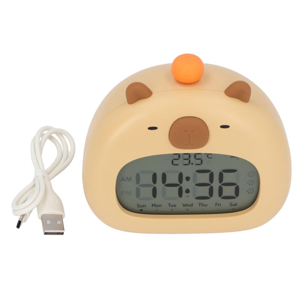 A cute, cartoon-like alarm clock shaped like a capybara, with a digital display showing the time and temperature, and a USB charging cable next to it.