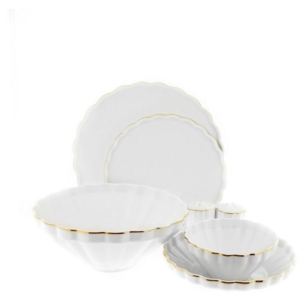 A white porcelain dinnerware set with gold trim, including plates, bowls, and salt and pepper shakers.