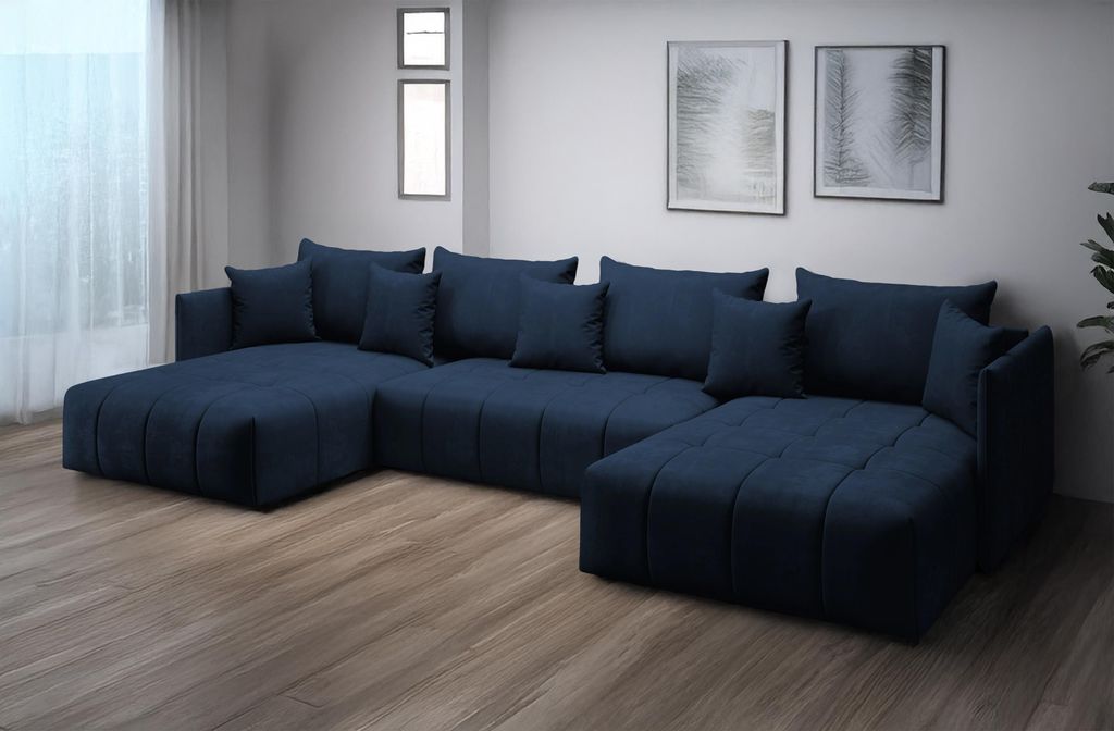 A navy blue U-shaped sectional sofa with multiple cushions is shown in a well-lit room with wooden floors and two framed pictures on the wall.