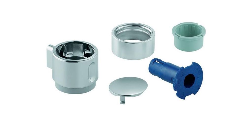 A collection of plumbing parts, including a chrome handle, a silver cap, a green plastic insert, and a blue plastic fitting, arranged on a white background.