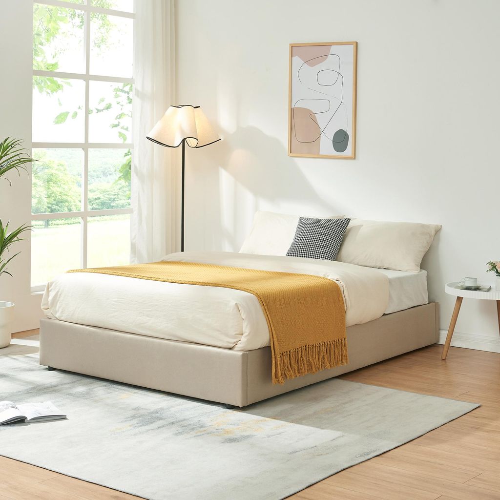 A bedroom scene with a bed, lamp, and artwork.
