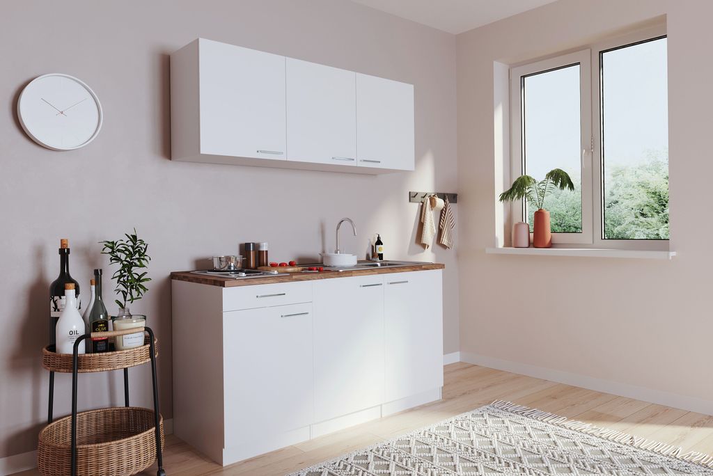 A clean, modern kitchen setup with white cabinets and a wooden countertop.