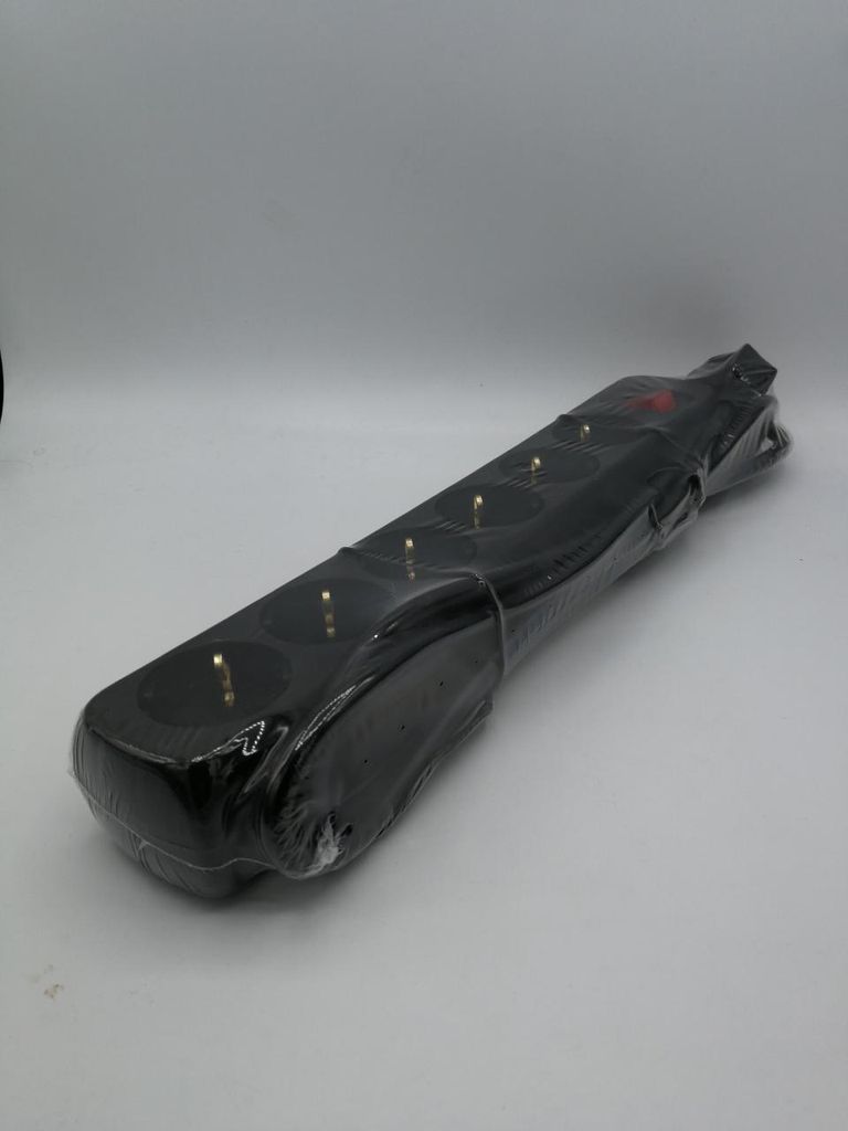 A black power strip is shown on a white background, wrapped in clear plastic.