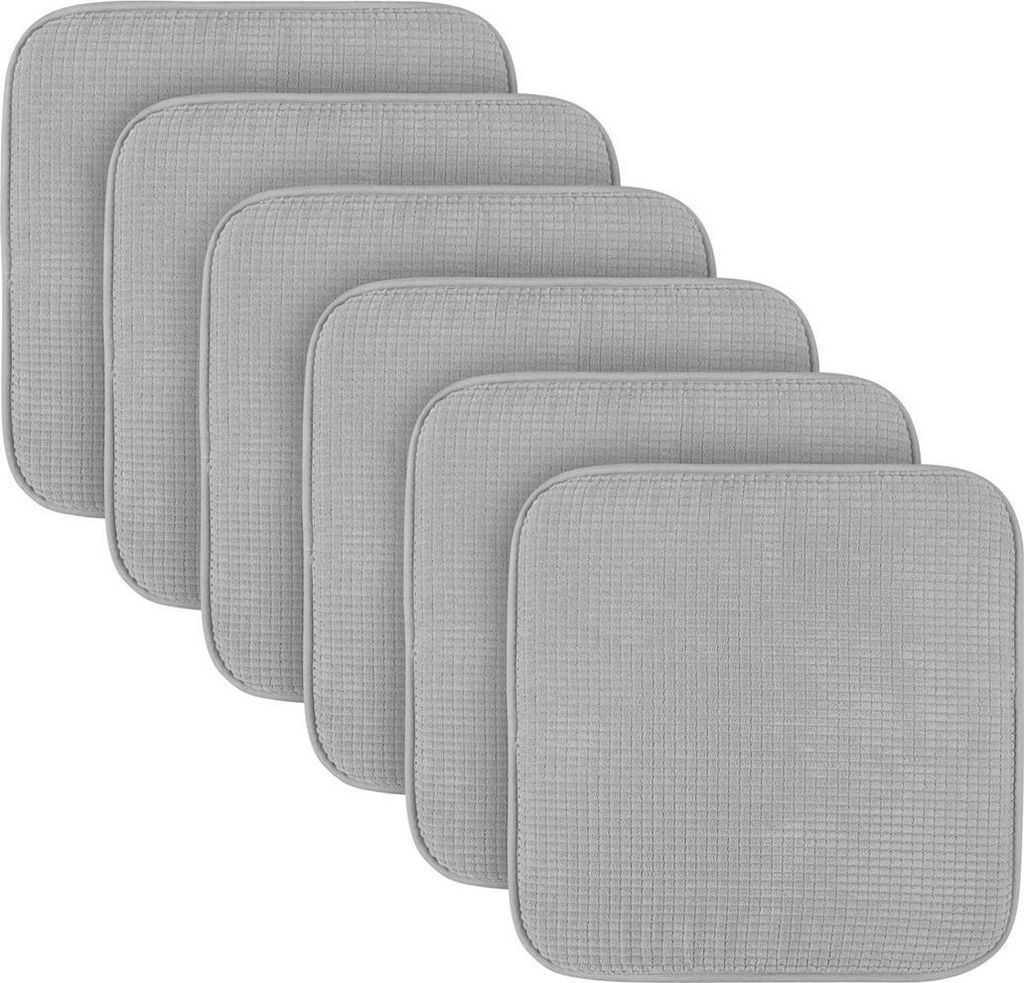 A stack of six grey square seat cushions, arranged in a staggered diagonal pattern.
