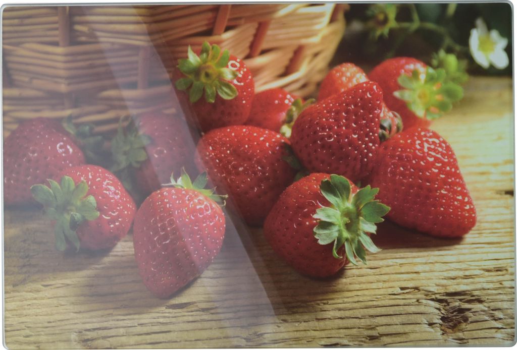 Strawberries are arranged on a wooden surface, with a basket in the background.