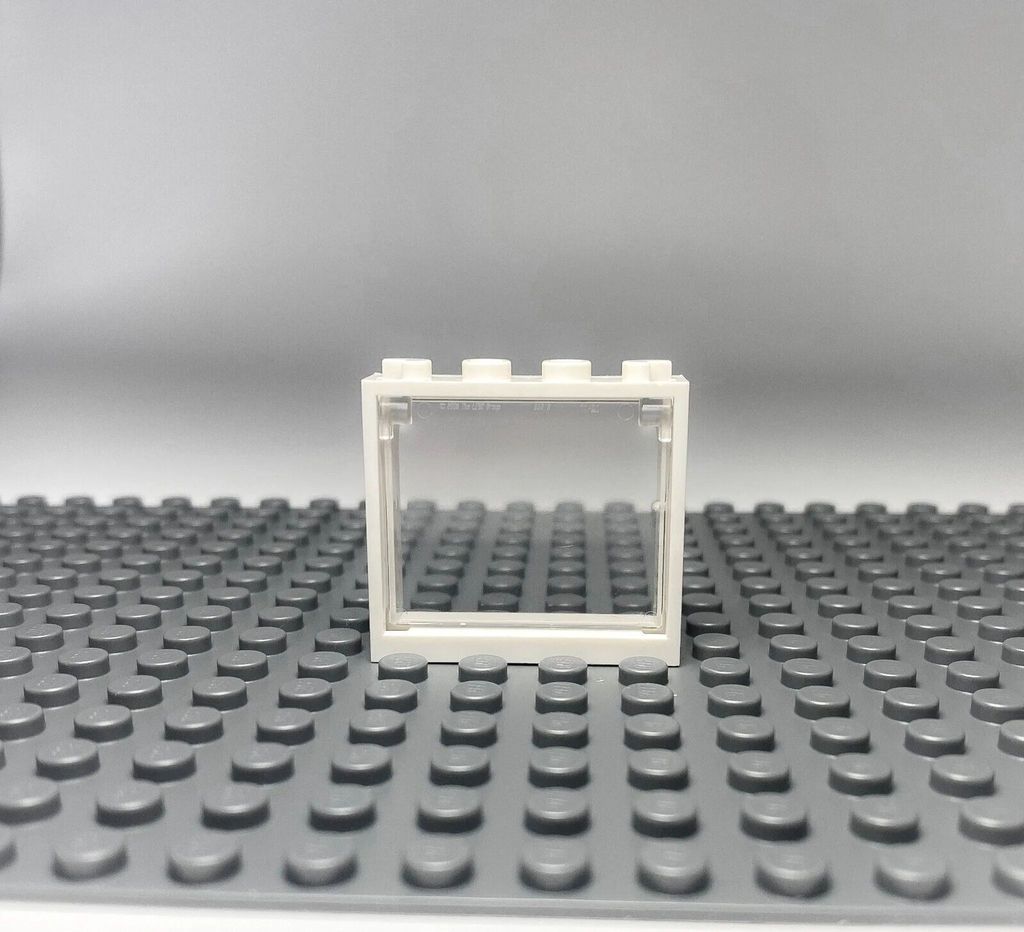 A white LEGO window frame with a transparent pane, placed on a gray LEGO baseplate.