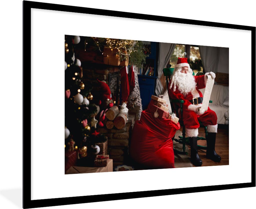 MuchoWow Gerahmtes Poster Der Weihnachtsmann sitzt auf einem Stuhl mit einem Sack voller Geschenke 90x60 cm - Poster mit Schwarzem Bilderrahmen W...