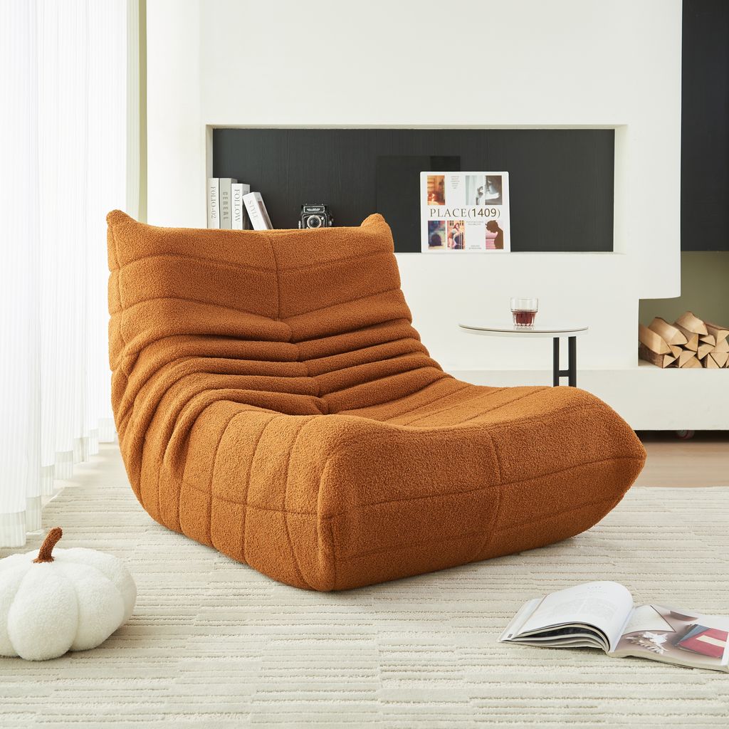 A cozy living room scene with a prominent orange armchair.