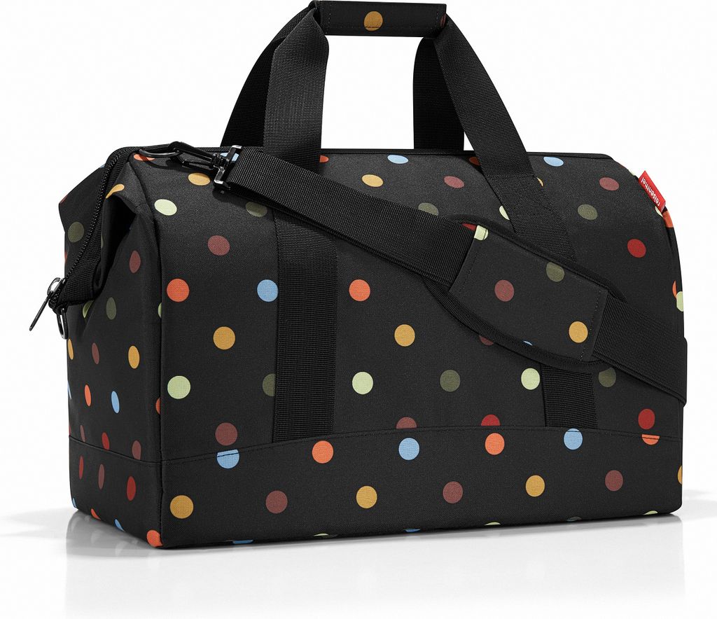 A black duffel bag with colorful polka dots.