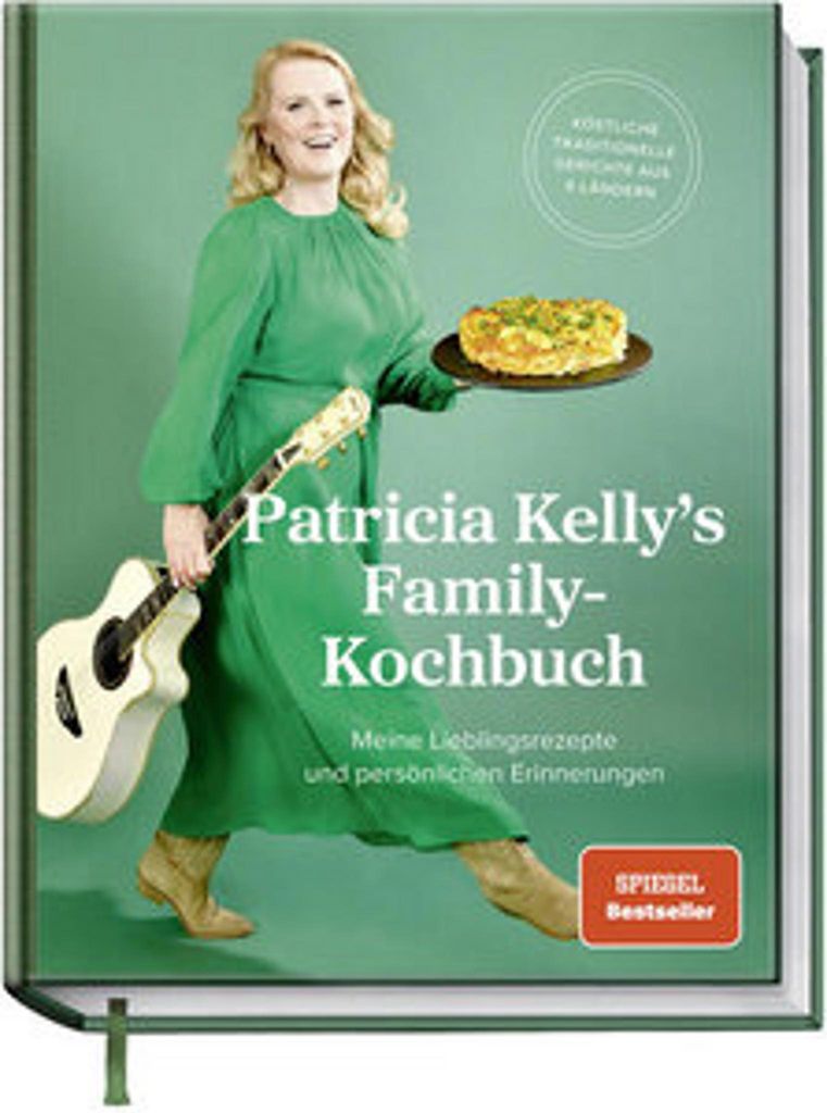 A woman holding a guitar and a pie, in front of a green background, with text overlay.