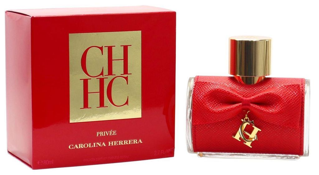 Rotes CH HC Privée Parfum von Carolina Herrera mit goldener Kappe, roter Schleife und Logo-Anhänger vor passender Verpackung.
