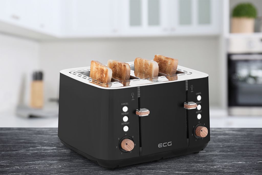 A black four-slice toaster with toast in it, placed on a dark wooden table in a kitchen setting.