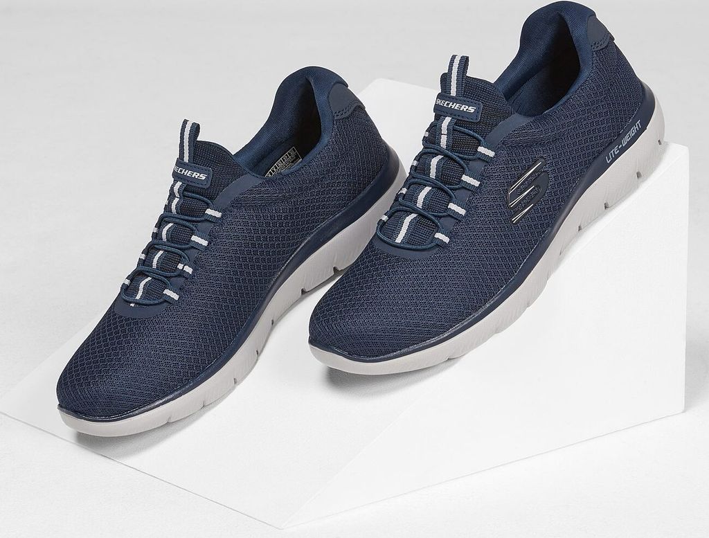 A pair of navy blue Skechers men's shoes are displayed on a white surface.