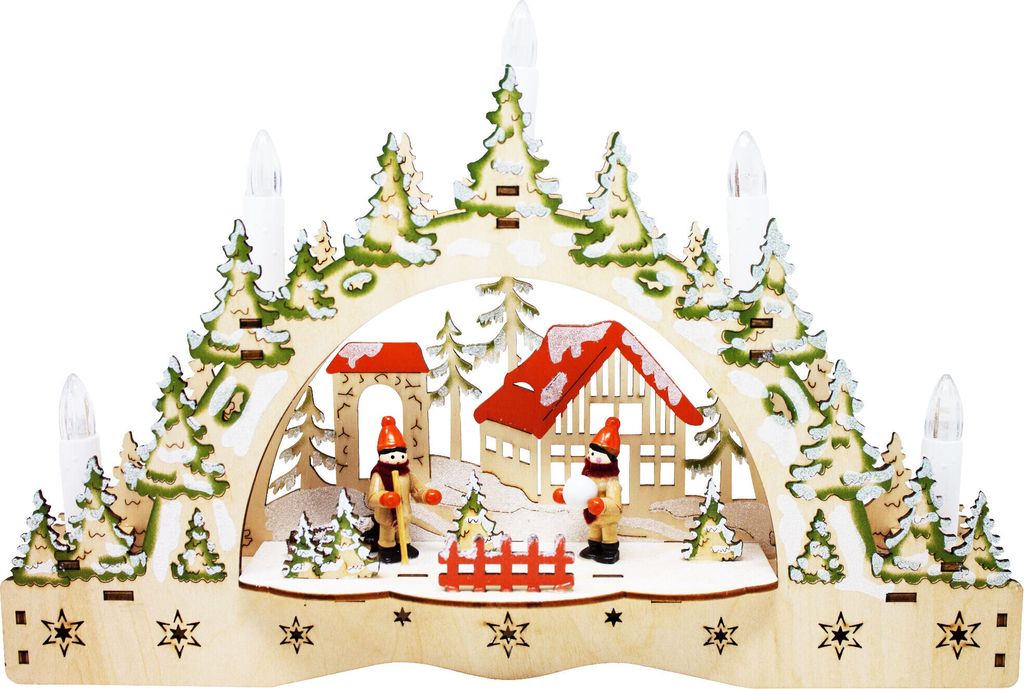 A wooden Christmas decoration depicting a winter scene with a house, trees, and figures.