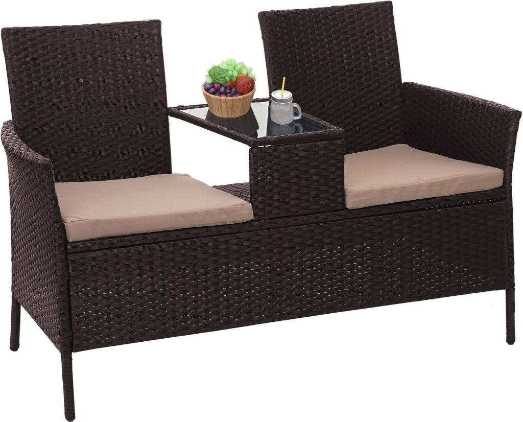 A brown poly-rattan bench with cream cushions and a small glass-top table in the center.