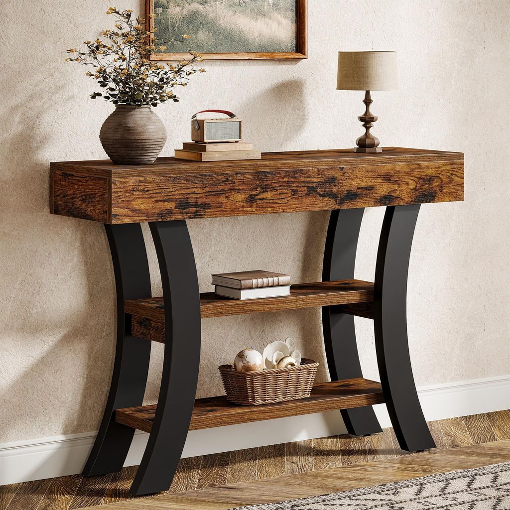 A rustic-style console table with shelves, decorated with a vase of flowers, books, and a basket of decorative items.