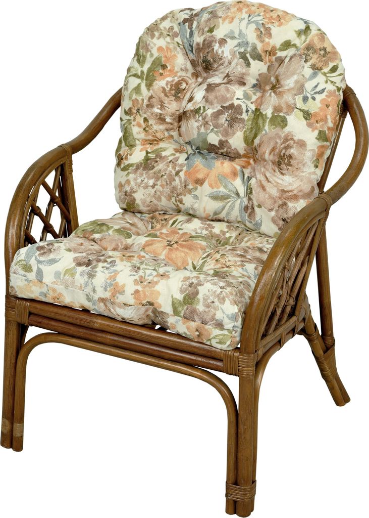 A rattan armchair with floral cushions.