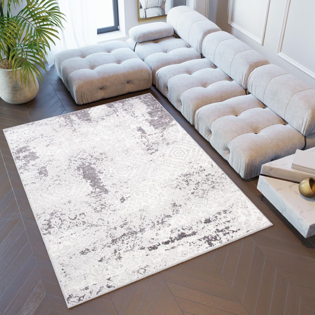 A modern living room with a large sectional sofa and a rug.