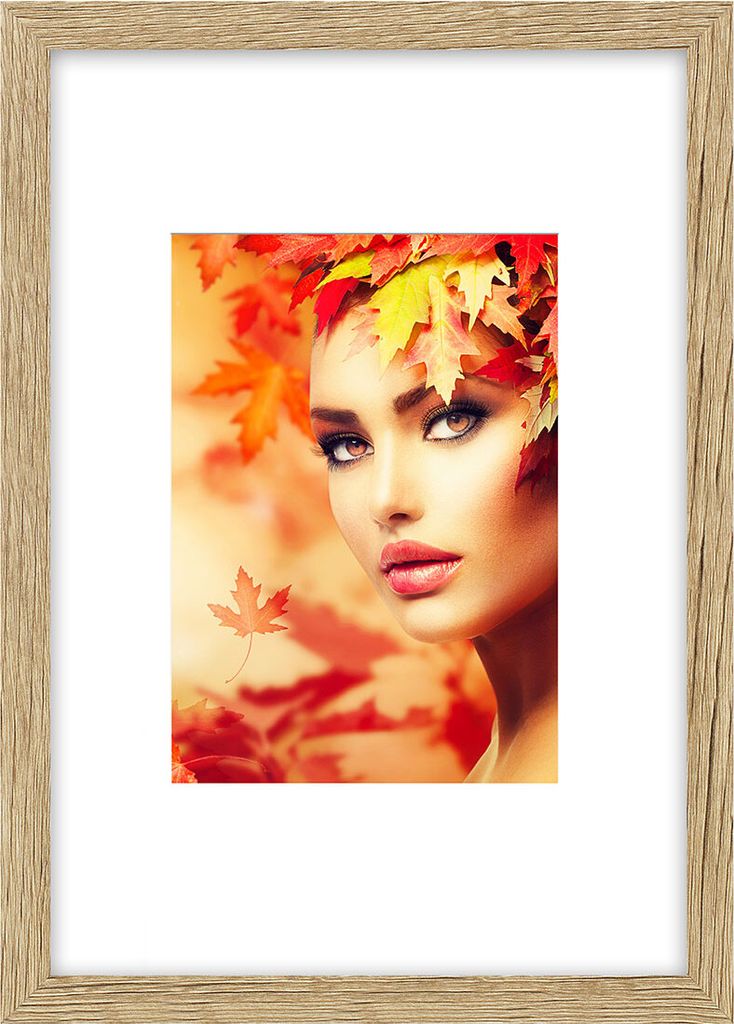 A woman with autumn leaves in her hair, with a blurred background of autumn leaves.