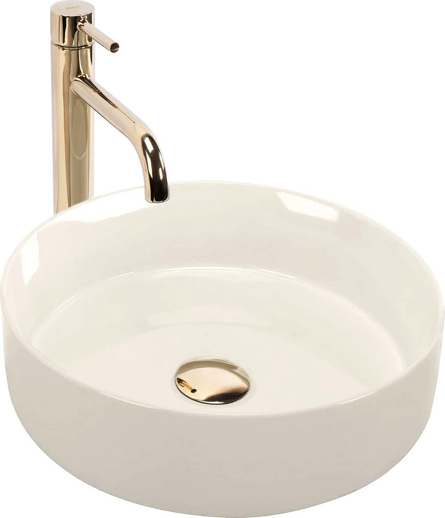 A white ceramic vessel sink with a gold faucet and drain.