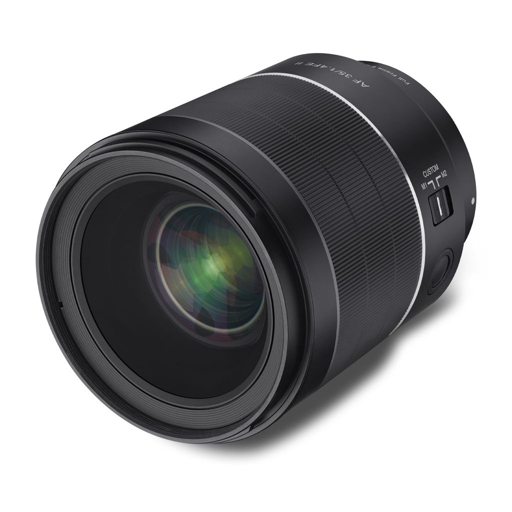 A close-up studio shot of a black camera lens against a white background.