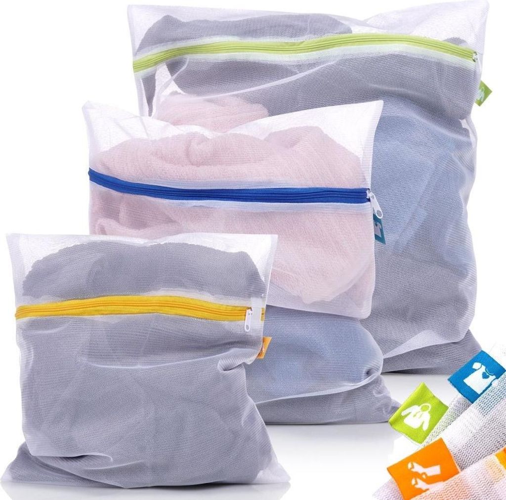 A set of three mesh laundry bags with different colored zippers, filled with clothes, arranged in a stack.
