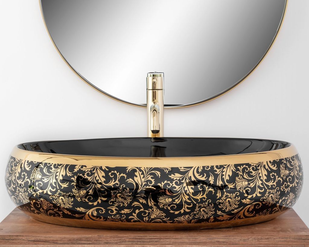 A close-up shot of a decorative washbasin with a gold faucet, set against a white background and a round mirror.